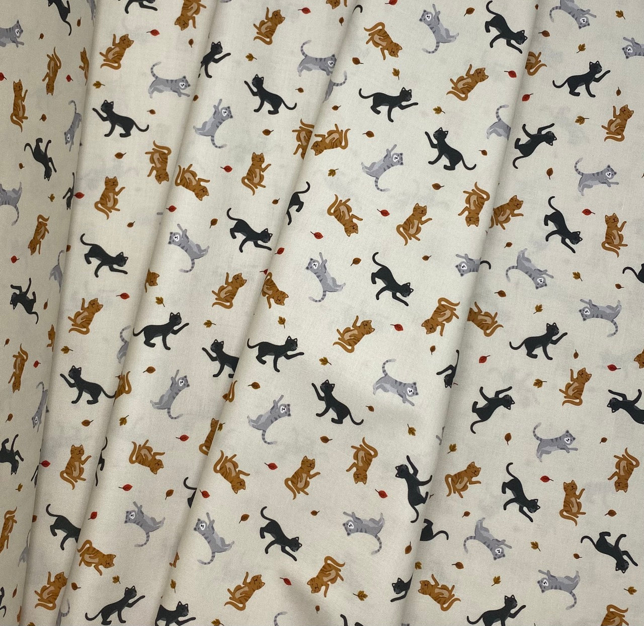Cats and falling leaves on cream
