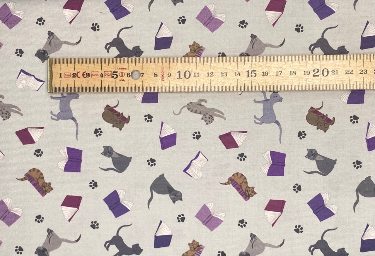 Scattered cats and books on grey